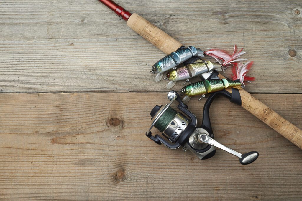 Colorful lures with the fishing rod on the wooden pier